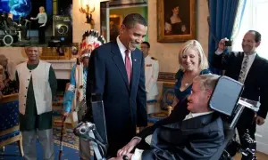 Barack Obama wita Stephena Hawkinga, naukowca na wózku, w Białym Domu. W tle widać innych gości i obrazy.