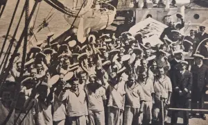 Marynarze na pokładzie statku "Dar Pomorza" w Gdyni. W tle widać żagle i maszty, a na pierwszym planie grupę ludzi w białych strojach. To jakby smuga cienia autorstwa historii.