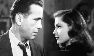 Para z filmu noir patrzy na siebie w zbliżeniu. Mężczyzna w garniturze, kobieta w czarnej sukni.