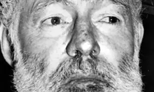 Zbliżenie na twarz Ernesta Hemingwaya z siwą brodą i zmarszczkami. Ciekawe fakty o pisarzu.