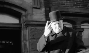 Winston Churchill z cygarem i kapeluszem, pokazujący znak zwycięstwa. Ciekawostki o nim często dotyczą jego charyzmy.