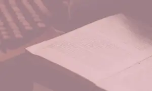 Otwarta księga z tekstem, przypominająca streszczenie Księgi Hioba, leży na stole.