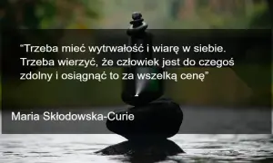 Kamienie ułożone w stos symbolizują wytrwałość i wiarę w siebie, jak w cytacie motywacyjnym Marii Skłodowskiej-Curie.