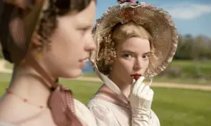 Emma, z powieści Jane Austen, w białej rękawiczce wkłada truskawkę do ust.