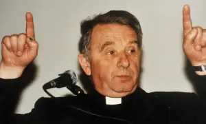 Ksiądz, autor historii filozofii po góralsku, podnosi dwa palce, jakby coś wyjaśniał.