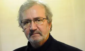 Portret mężczyzny w okularach, z siwiejącą brodą i wąsami. To znany polski satyryk, Krzysztof Daukszewicz.