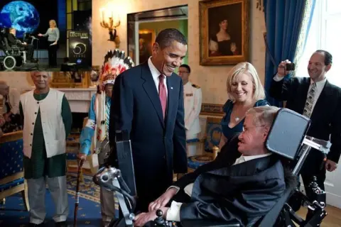 Barack Obama wita Stephena Hawkinga, naukowca na wózku, w Białym Domu. W tle widać innych gości i obrazy.