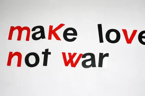 Napis "make love not war" w stylu pacyfista. Czerwone litery podkreślają przesłanie pokoju.