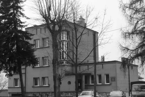 Szare budynki, jak szklane domy przedwiośnie, otoczone nagimi drzewami.