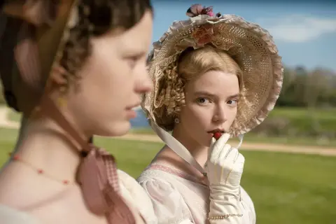 Emma, z powieści Jane Austen, w białej rękawiczce wkłada truskawkę do ust.