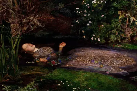 Ofelia, młoda kobieta, dryfuje w wodzie, otoczona kwiatami i zielenią. Jej twarz jest spokojna, a dłonie wyciągnięte.