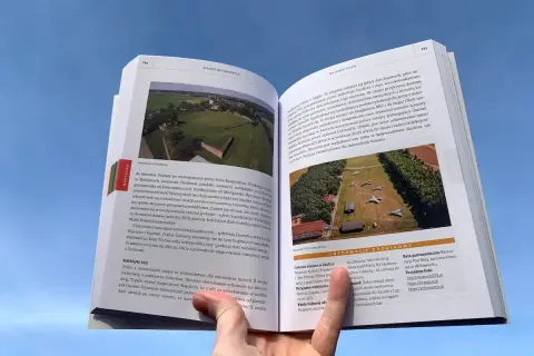 Otwarta książka z ilustracjami i tekstem o historii Śląska. Widać fragmenty o zamkach i lotnictwie. To ciekawe książki po śląsku.