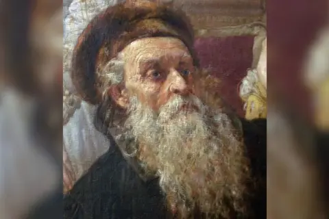Portret starszego mężczyzny z długą, siwą brodą i futrzaną czapką.