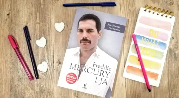Książka "Freddie Mercury i ja" leży obok kolorowych pisaków i notatnika.