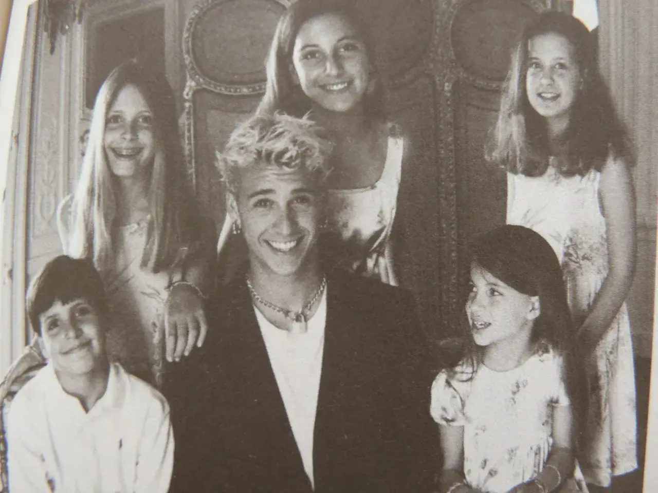 Uśmiechnięta grupa dzieci, być może danielle steel dzieci, pozuje do zdjęcia w eleganckim wnętrzu.