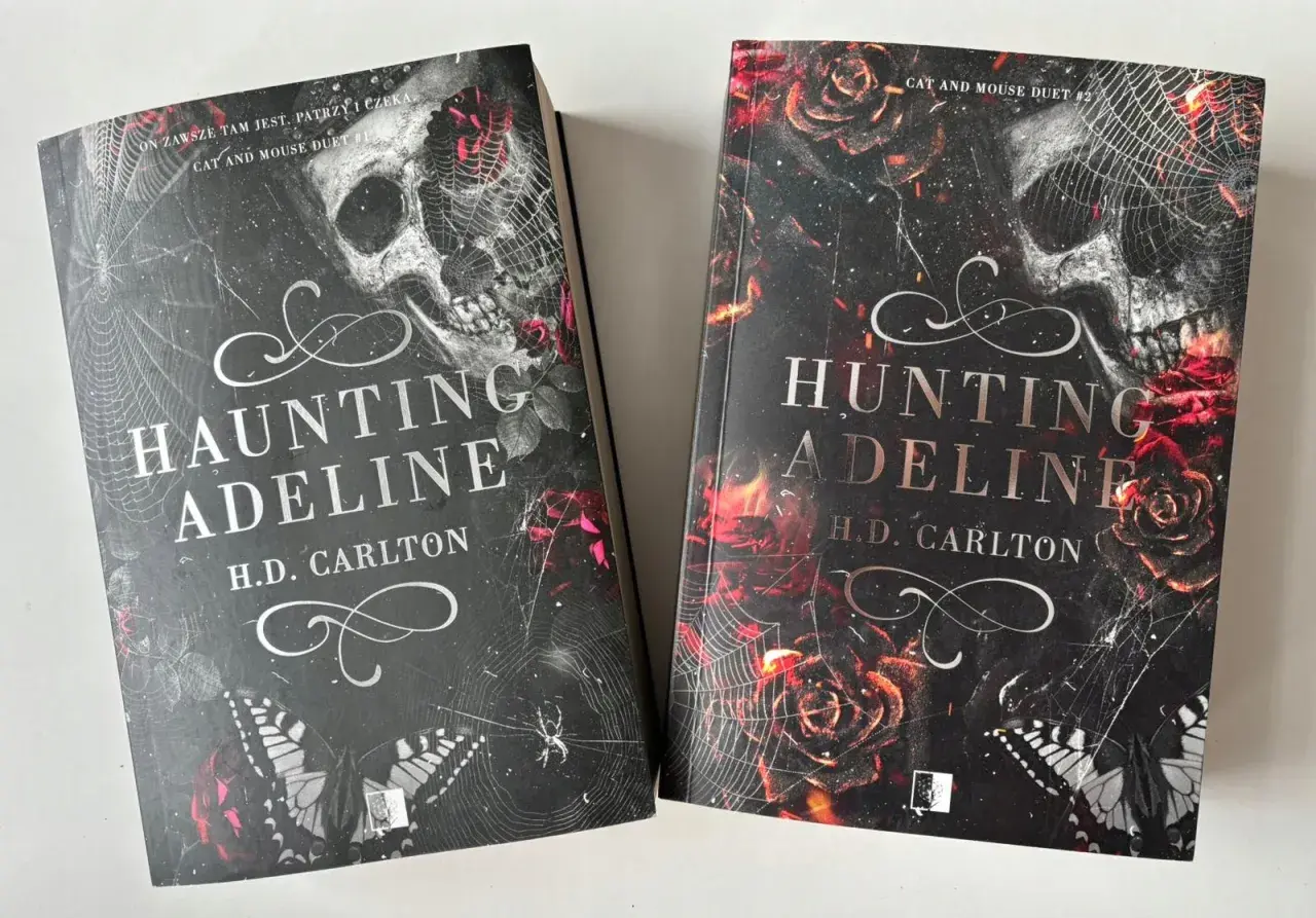 Dwie książki "Haunting Adeline" i "Hunting Adeline" H.D. Carlton. Mroczne okładki z czaszką, różami i pajęczyną.