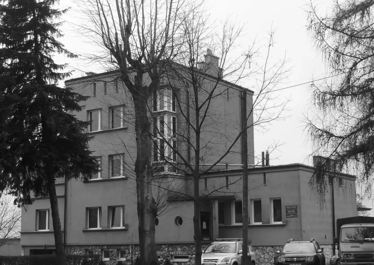Szare budynki, jak szklane domy przedwiośnie, otoczone nagimi drzewami.