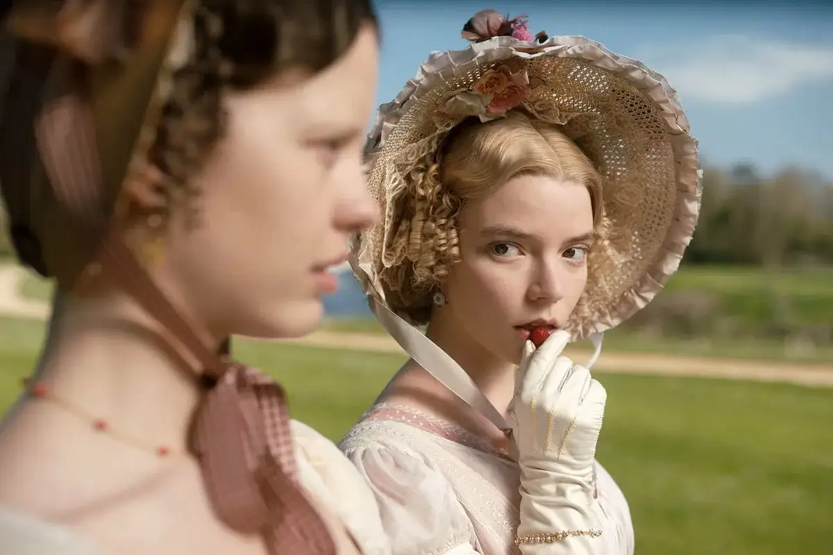 Emma, bohaterka powieści Jane Austen, w kapeluszu i rękawiczkach, z truskawką w dłoni.