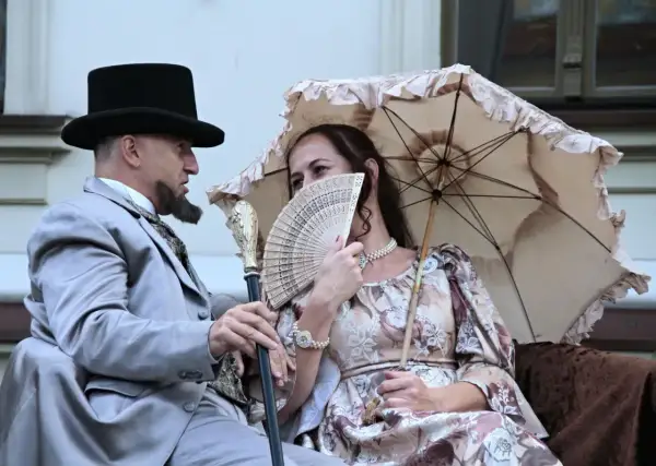 Para jak z obrazu, lalka bohaterowie w strojach z epoki, mężczyzna z wąsem i cylinder, kobieta z wachlarzem i parasolką.