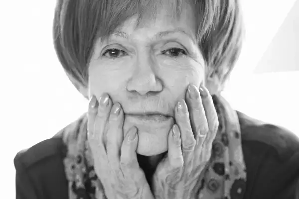 Portret Marii Czubaszek, z dłońmi opartymi o policzki. Jej spojrzenie przywodzi na myśl jej słynne maria czubaszek cytaty.